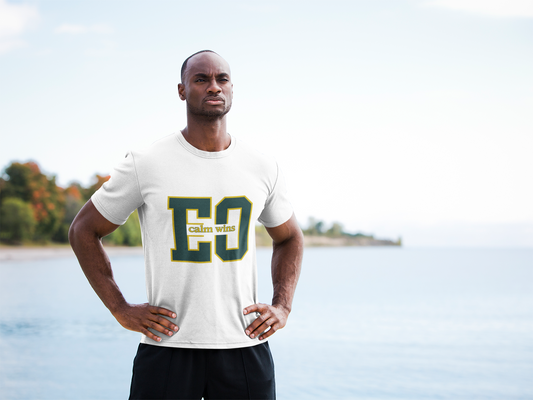 Man wearing a white t-shirt with 'Calhoun College' text standing by a lake.