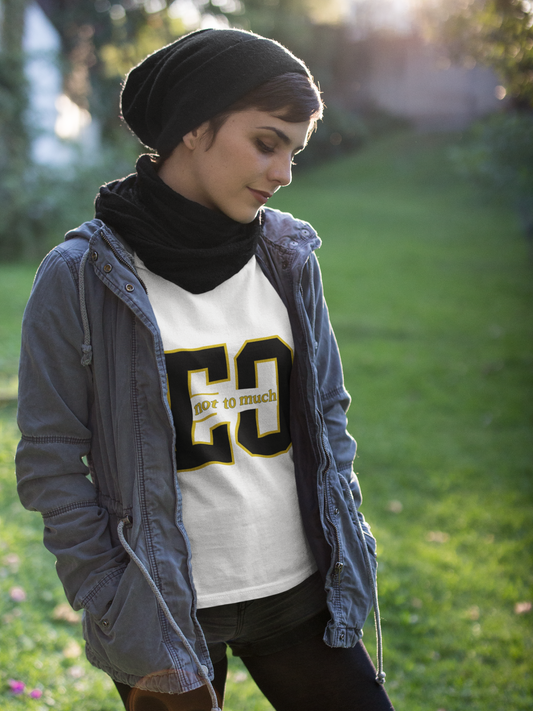 Person wearing a gray jacket and white sweatshirt with text, standing outdoors on grass.