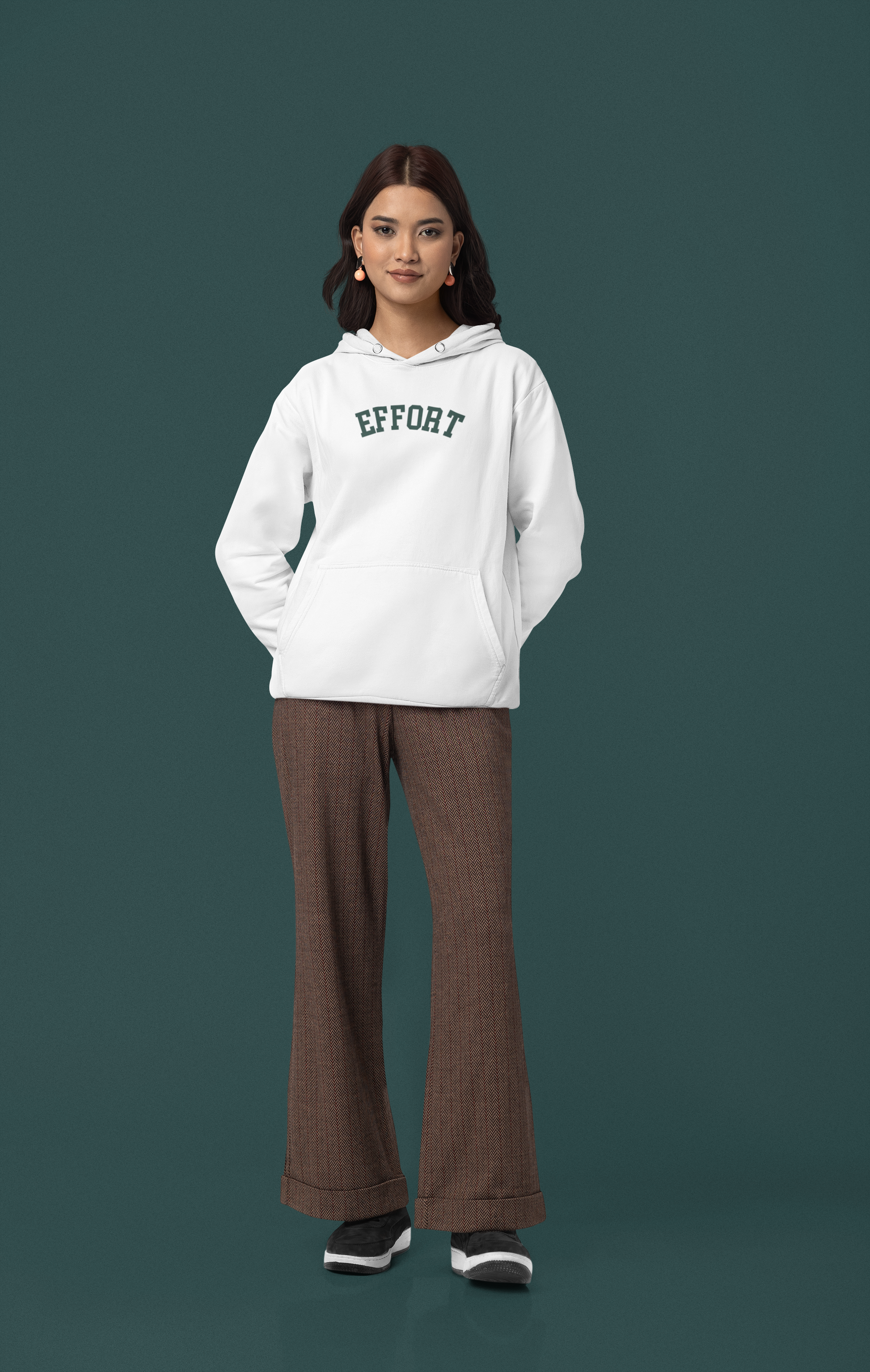 Person wearing a white hoodie with 'EFFORT' text and brown pants on a dark green background