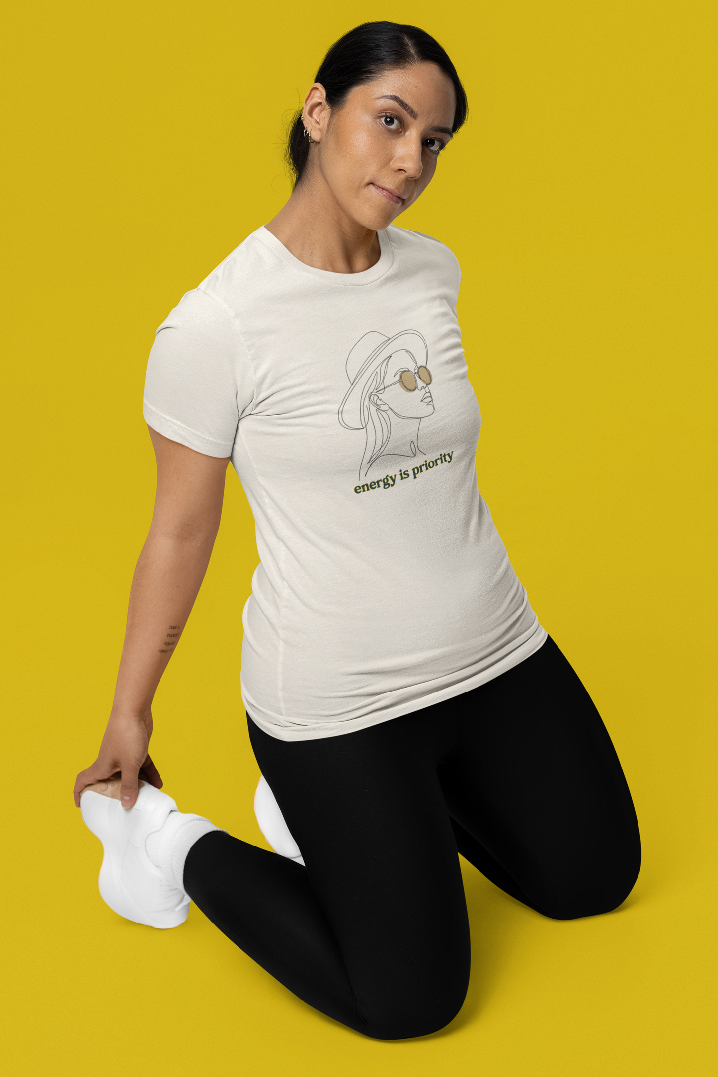Woman wearing a white t-shirt with a graphic design on a yellow background