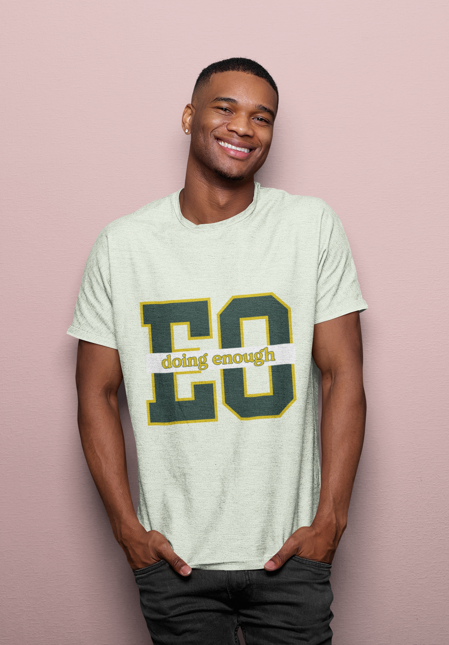 Man wearing a light green t-shirt with text on a pink background