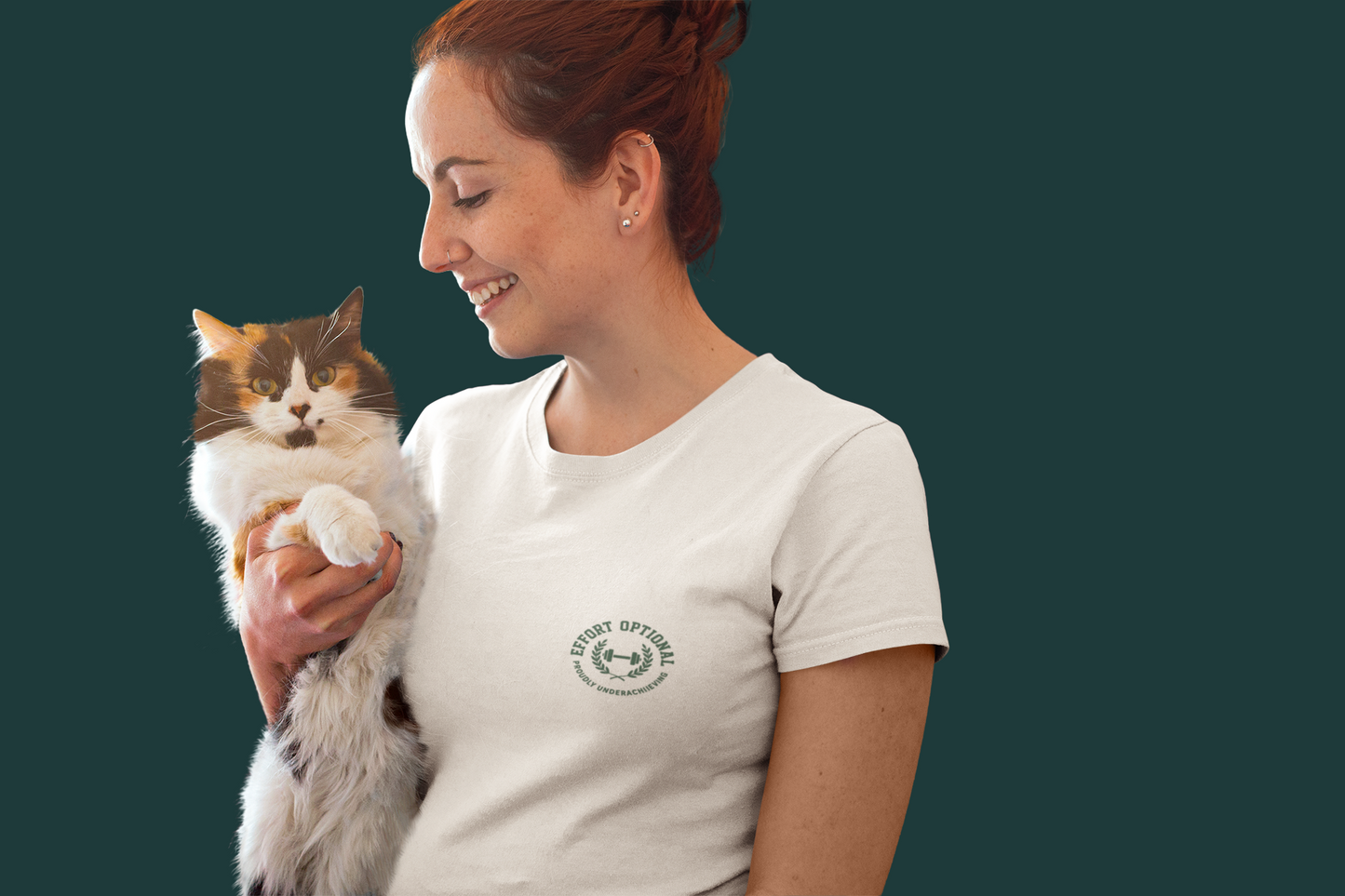 Woman holding a cat wearing a white t-shirt with a logo on a dark background