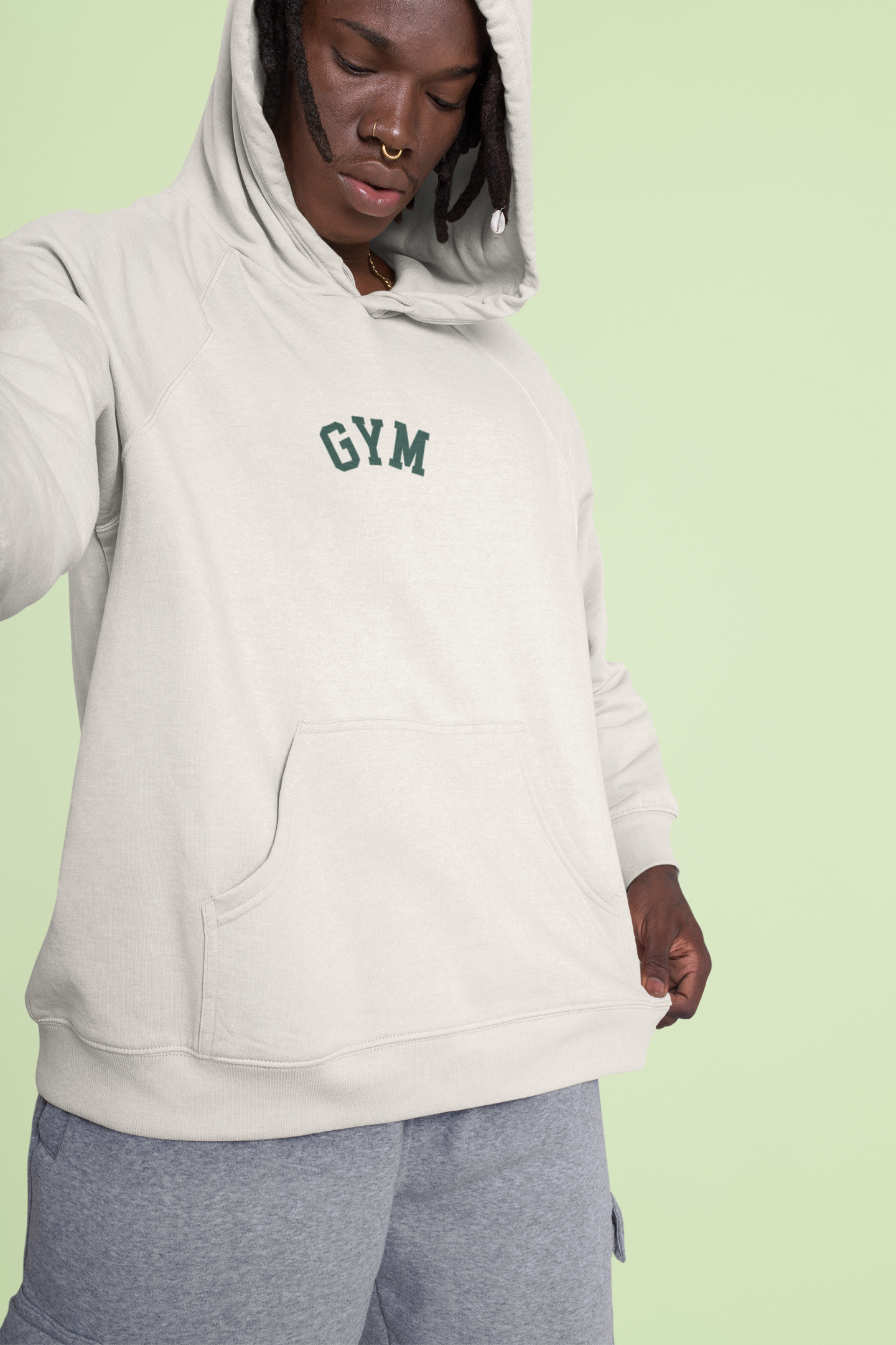 Person wearing a gray hoodie with 'GYM' text on a light green background