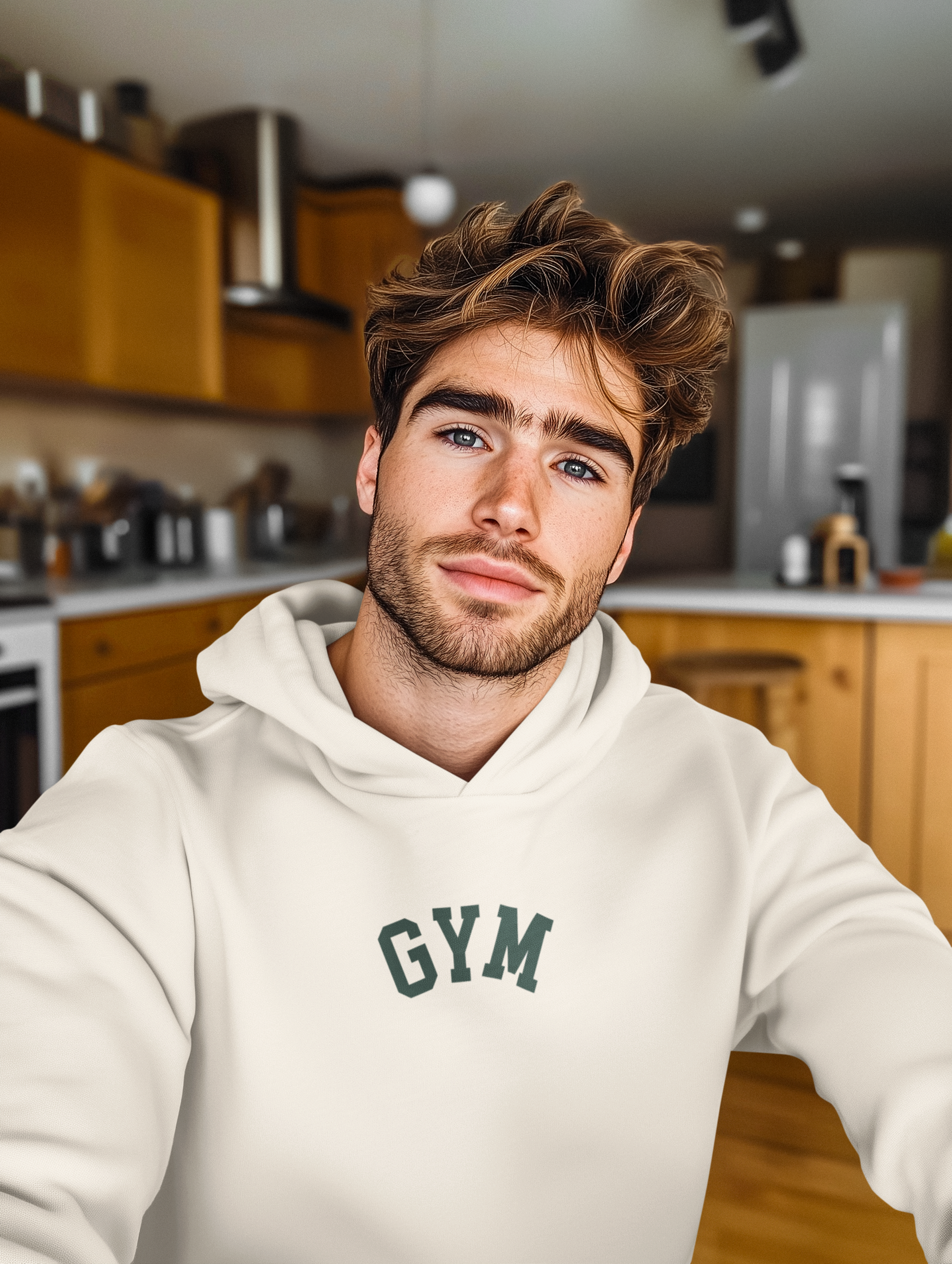 Man wearing a white hoodie with 'GYM' text in a kitchen setting