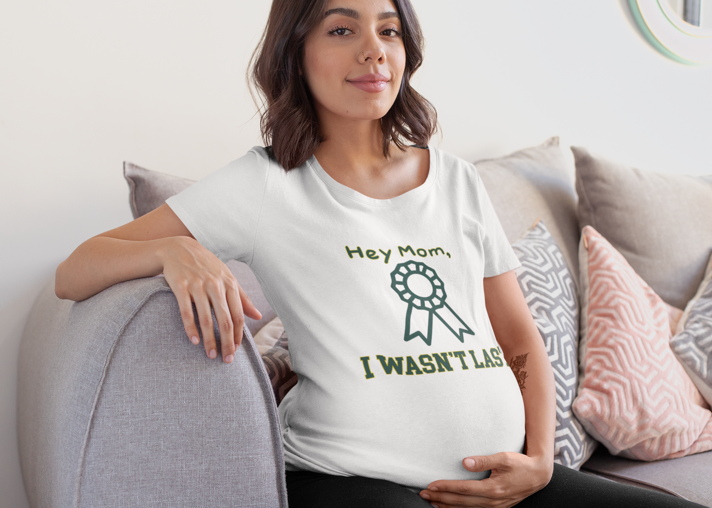 Woman wearing a white t-shirt with a graphic and text, sitting on a couch.