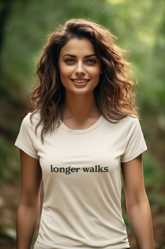 Woman wearing a white t-shirt with 'longer walks' text in a natural setting