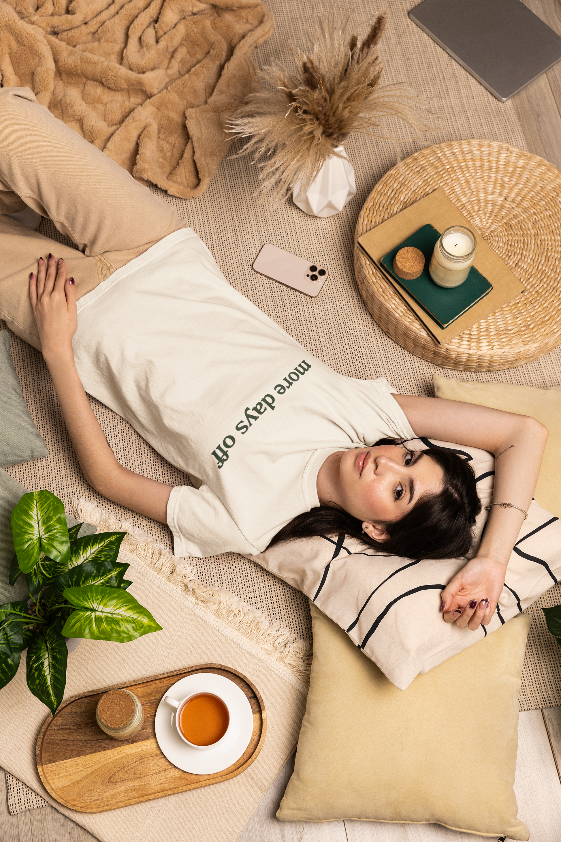 Woman lying on a couch with a coffee cup and phone on a small table.