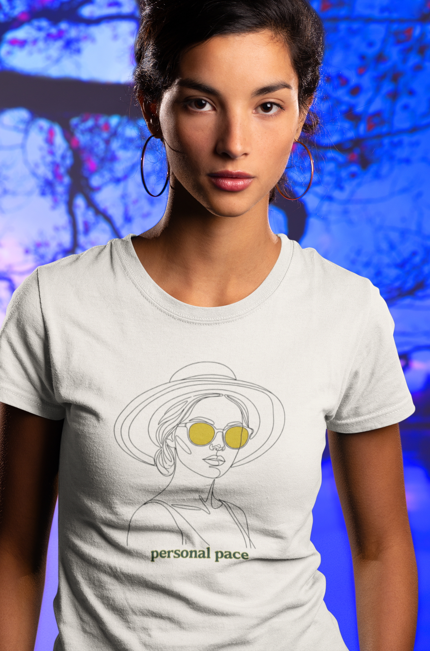 Woman wearing a white t-shirt with a graphic design and text against a blue abstract background