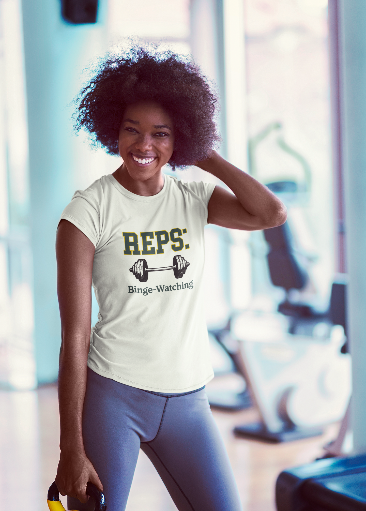 Woman in a gym wearing a t-shirt with 'REPS: Binge-Watching' text.