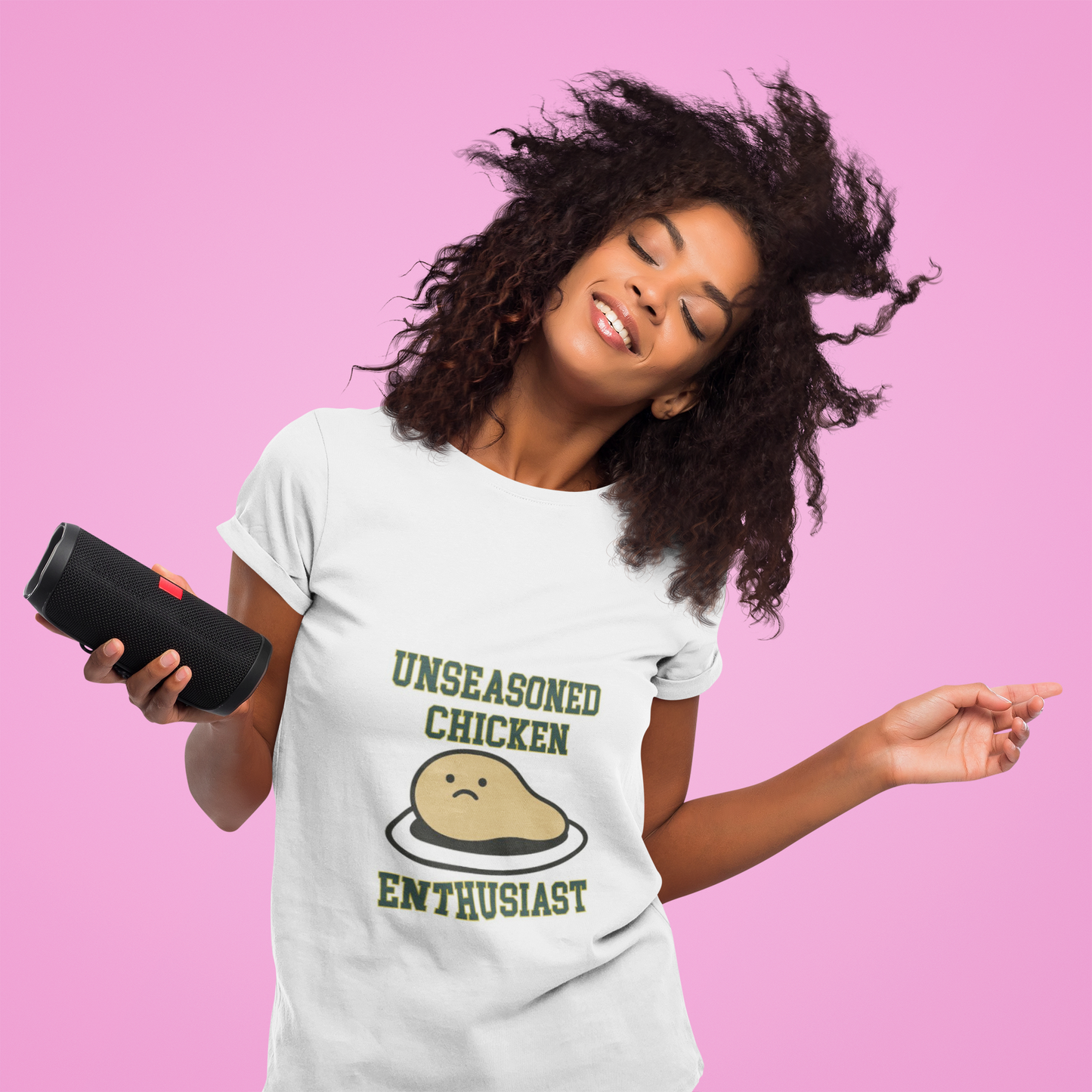 Woman wearing a t-shirt with 'Unseasoned Chicken Enthusiast' graphic on a pink background