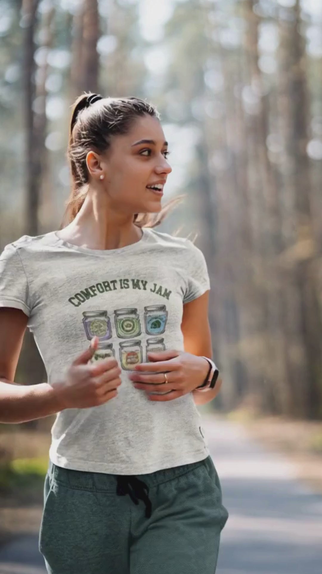 Woman wearing a t-shirt with 'Comfort is my Jam' design in a forest setting.video